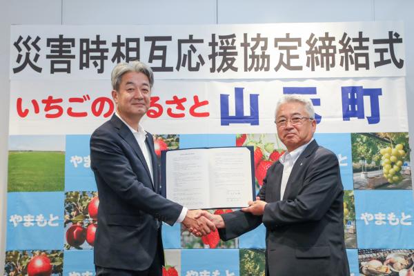 締結式で握手する穴水町長と山元町長